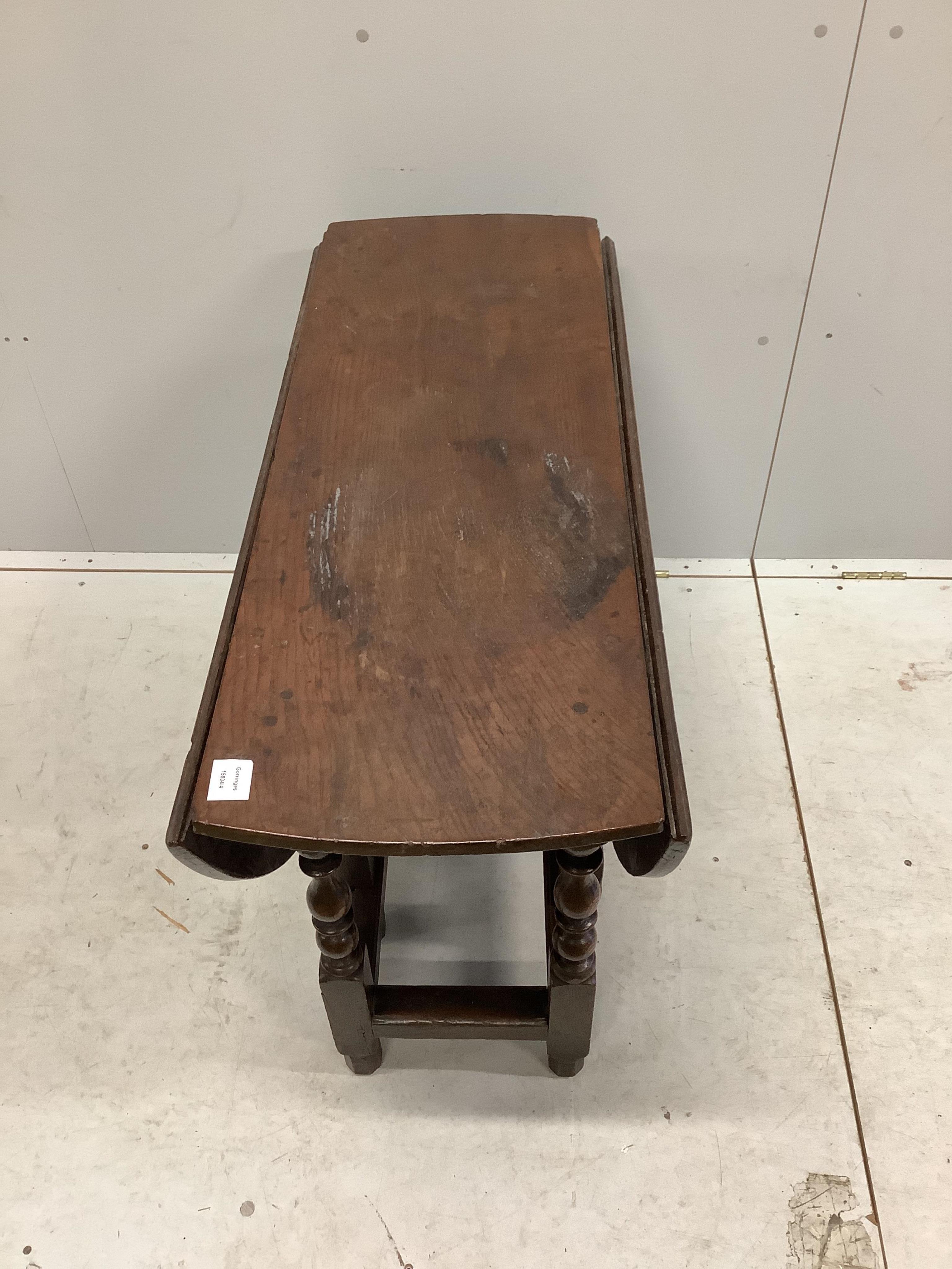 An 18th century oak gateleg table with an oval top on baluster turned under frame, 112cm extended, depth 100cm, height 68cm. Condition - fair